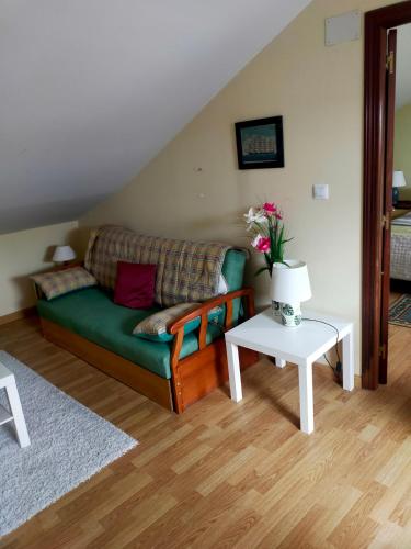 a living room with a green couch and a table at La Gaviota in Ferrol