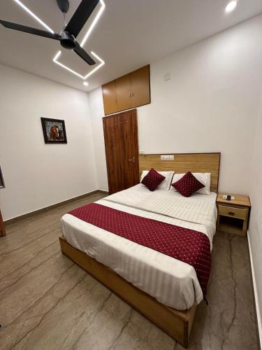 a bedroom with a large bed with red pillows at Grandstaykannur in Kannur