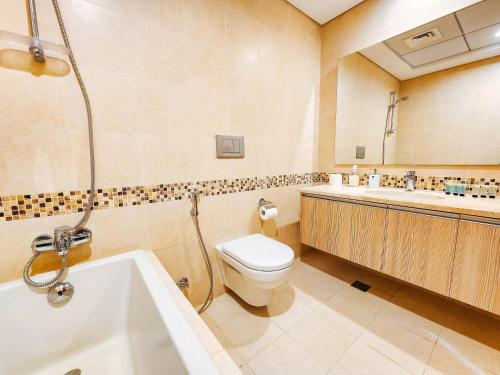 Un baño con inodoro, bañera y lavabo. en HARF-G13 Fancy 1BR with Big Balcony in YAS Island, en Abu Dabi
