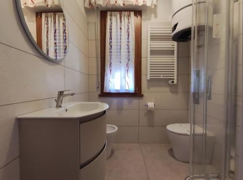 a bathroom with a sink and a toilet and a mirror at Conero - Patio Privato e Parcheggio by Host Hero in Marcelli
