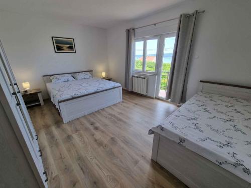 - une chambre avec 2 lits et une grande fenêtre dans l'établissement Apartment in Dramalj 33974, à Dramalj