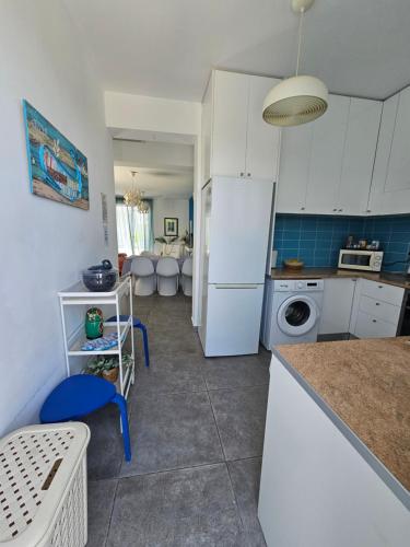 a kitchen with white cabinets and a white refrigerator at Blue Diamond Beach Villas in Paphos City