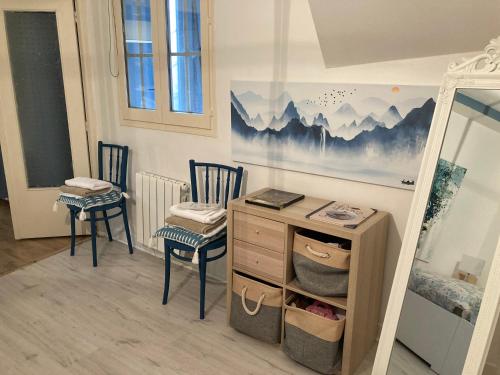 une chambre avec deux chaises, un bureau et un tableau dans l'établissement Cocon Bleu, à Troyes
