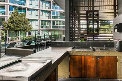 una cocina con dos lavabos y un gran edificio en 1-Bedroom Riverfront Apartment with Pool, en Brisbane