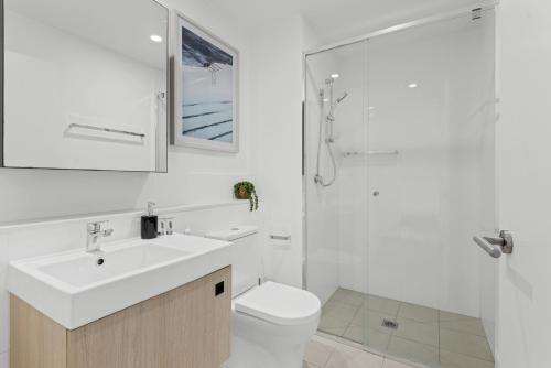 La salle de bains est pourvue d'un lavabo, de toilettes et d'une douche. dans l'établissement Cityscape 2-Bed with Pool, Gym & Secure Parking, à Brisbane