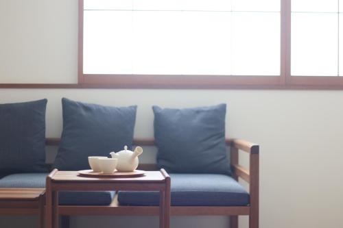 a table with a tea pot on top of a couch at Hotel Rakurakuan in Kyoto