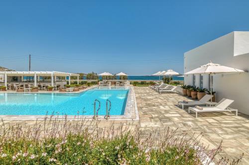 a swimming pool with chairs and umbrellas at a resort at Villa Bellonia in Naousa