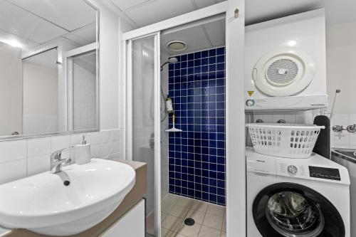 a bathroom with a sink and a washing machine at Prime City Residence with Pool, Gym and Parking in Brisbane