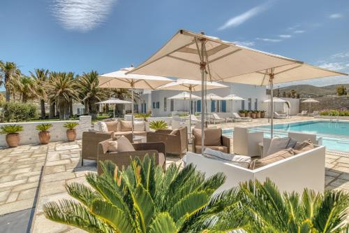 a patio with chairs and umbrellas next to a pool at Villa Bellonia in Naousa