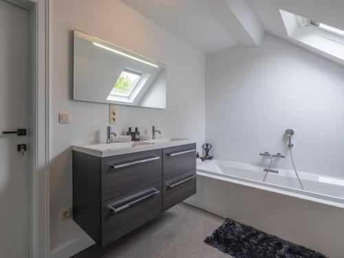 a bathroom with a sink and a bath tub at Maison Idyllique in Bree