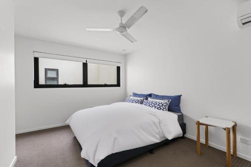 a bedroom with a bed and a window at Sleek City Apartment with Parking and Balcony in Brisbane
