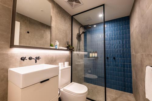 y baño con aseo y ducha acristalada. en Sleek 1-Bed Apartment With Rooftop Pool en Brisbane