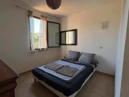 1 dormitorio con 1 cama con sábanas azules y espejo en Villa St James en LʼÎle-Rousse