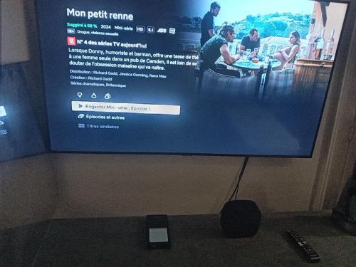 une télévision avec un écran avec des gens dessus dans l'établissement J.O STADE, à Saint-Denis