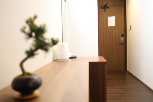 a plant sitting on a table next to a door at Hotel Rakurakuan in Kyoto