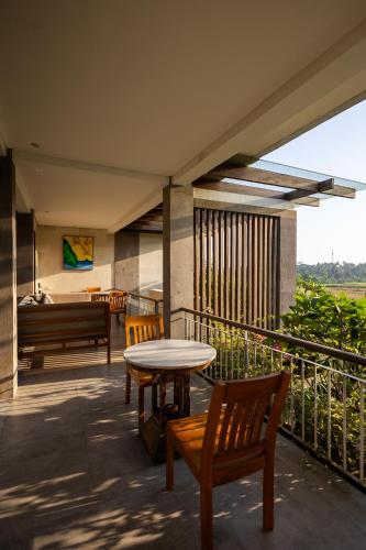 a patio with a table and chairs and a piano at Prabhu Ubud Villa in Ubud