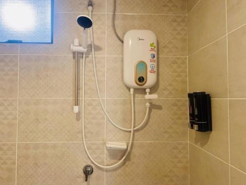 a shower in a bathroom with a soap dispenser at Mutiara Melaka Beach Resort by Glex in Tangga Batu