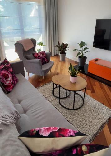 a living room with a white couch and a table at Villa Hoff Wellness & Spa in Trzęsacz