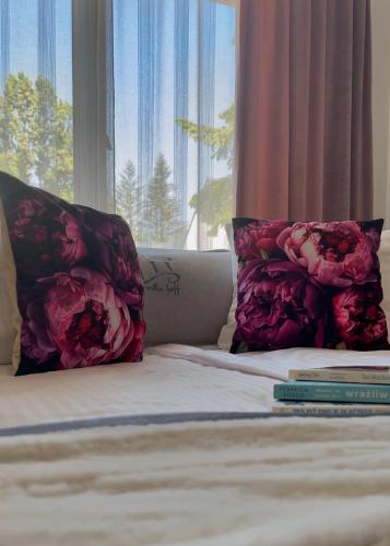a bed with two pillows on it with a window at Villa Hoff Wellness & Spa in Trzęsacz