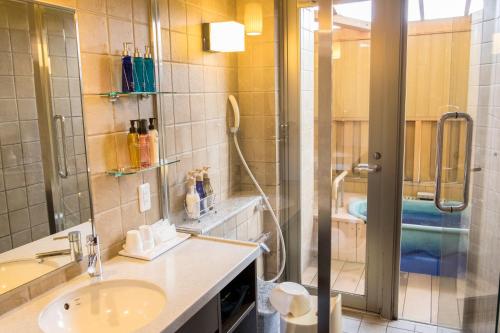 a bathroom with a shower and a sink and a shower at Kintarou Onsen Hotel in Uozu