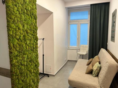 a living room with a couch and a green wall at Apartament Starowiślna in Krakow