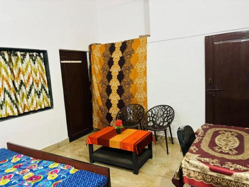 a room with a bed and a table and curtains at Shukla Guest House in Durg