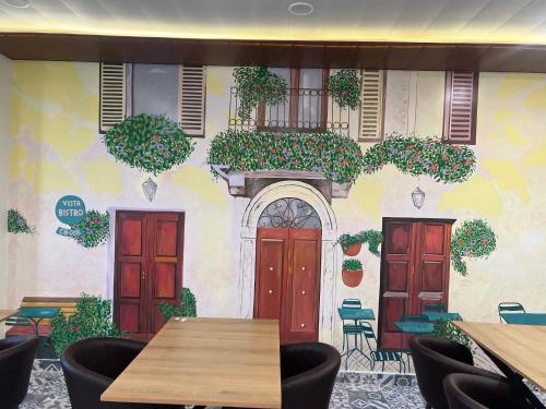 a restaurant with red doors and a wall with plants at The Blue Vista in Greater Noida