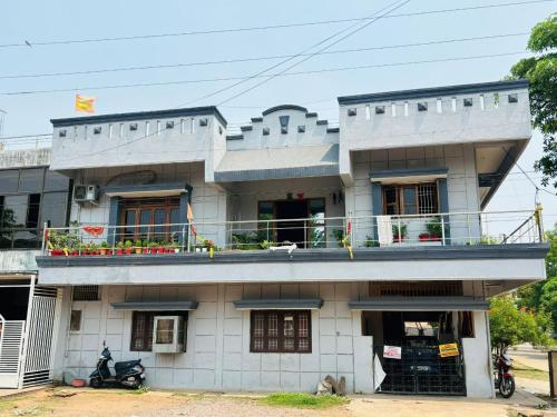 a white building with a balcony on top of it at Shukla Guest House in Durg