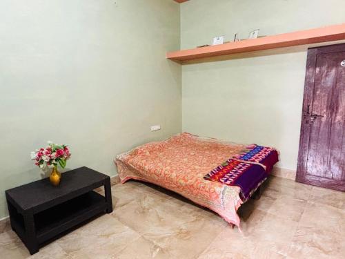 a bedroom with a bed and a vase of flowers at Shukla Guest House in Durg