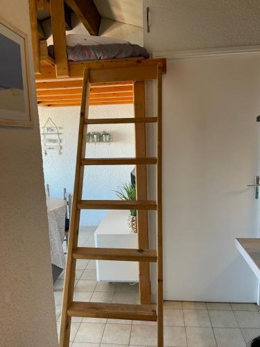 Ce lit superposé se trouve dans un dortoir avec une échelle. dans l'établissement La plage, à Frontignan