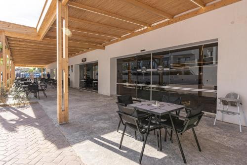 an outdoor patio with a table and chairs at Caretta Paradise Resort & WaterPark in Tragaki
