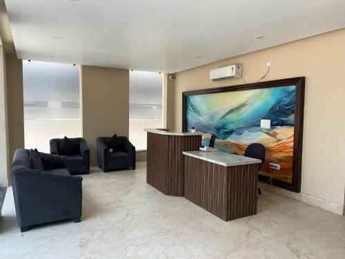 a waiting room with a large painting on the wall at The Blue Vista in Greater Noida