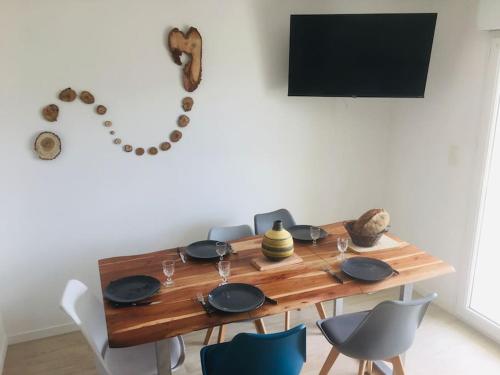 mesa de comedor con platos, tazones y sillas en L'escale marine, en Pléneuf-Val-André