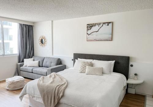 - une chambre blanche avec un lit et un canapé dans l'établissement Privately Owned Hotel Room in Beachside Resort - Sleeps 4, à Marcoola