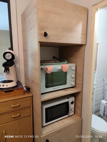 d'un placard avec un four micro-ondes et un grille-pain. dans l'établissement location appartement T1 hyper centre 350 m des thermes 200 m des télécabines deuxième étage avec ascenseur, à Luchon