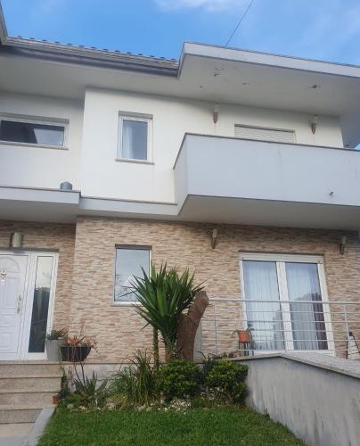 a house with a balcony and a fence at Grace House in Belinho