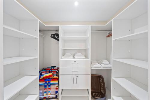 a white walk in closet with white shelves at Divi Village Condo 33 J.E. Irausquin Blvd 93 in Palm-Eagle Beach