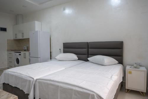 a bedroom with a large white bed with two pillows at Gama Palace in Batumi