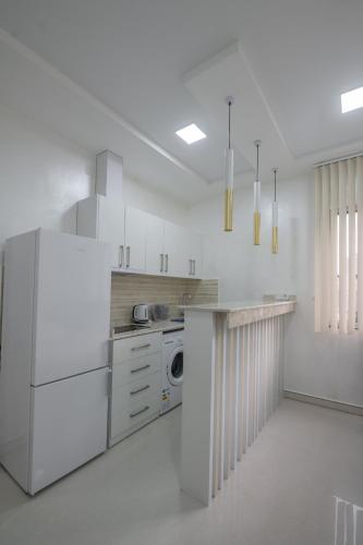 a white kitchen with a counter and a dishwasher at Gama Palace in Batumi