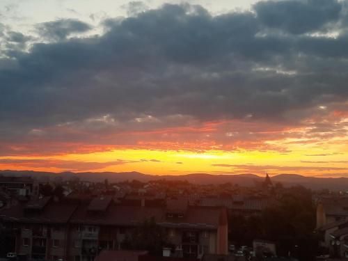 einen Blick auf den Sonnenuntergang über einer Stadt mit Bergen in der Unterkunft Apartament Browarna in Nowy Sącz