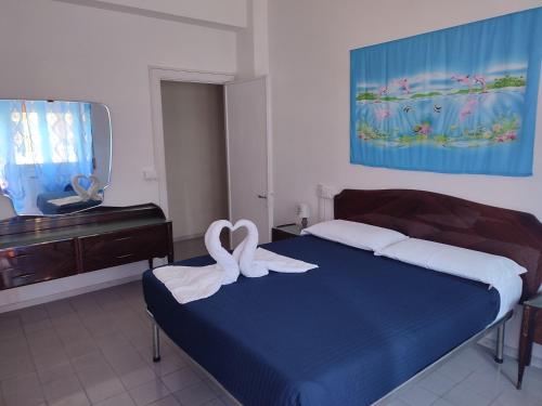a bedroom with a bed with two white towels on it at Sun & Beach Vasco De Gama by ACS HOLIDAYS in Lido di Ostia