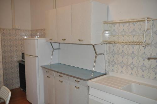 a kitchen with white cabinets and a refrigerator at Sun & Beach Vasco De Gama by ACS HOLIDAYS in Lido di Ostia
