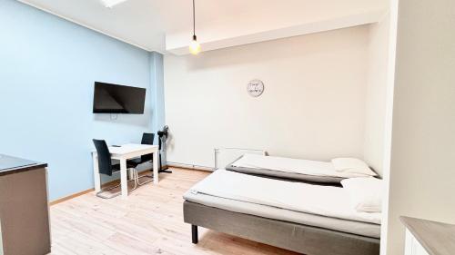a bedroom with a bed and a desk and a tv at Kastanimaja Apartments in Tartu