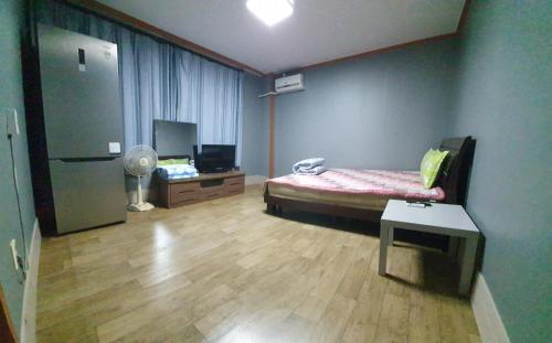 a room with a bed and a table in it at Green Valley in Sancheong