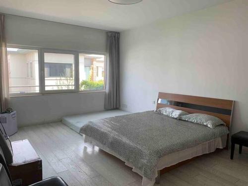 a bedroom with a bed and a large window at Yanjiao Villa in Beijing