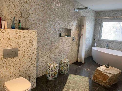 a bathroom with a tub and a toilet and a sink at Yanjiao Villa in Beijing
