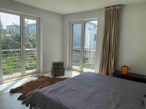 a bedroom with a large bed and large windows at Yanjiao Villa in Beijing