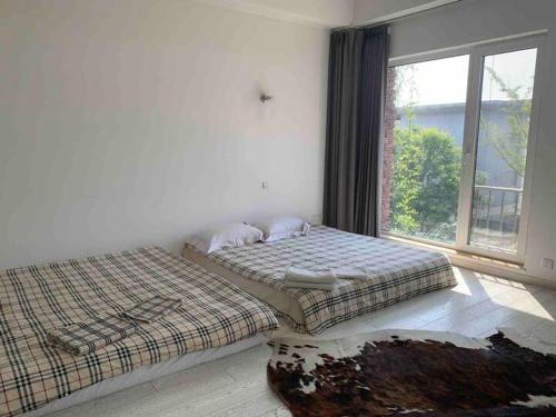 two beds in a room with a window at Yanjiao Villa in Beijing