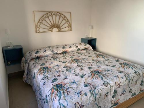 una camera da letto con un letto con copriletto floreale e 2 altoparlanti di Casa vacanze Marubium a Maruggio