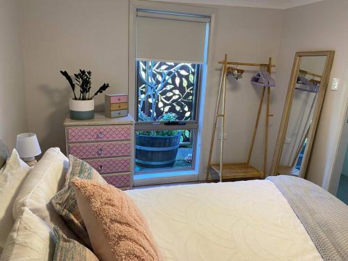 a bedroom with a bed and a window with a potted plant at Gwynnie Getaway in Gwynneville